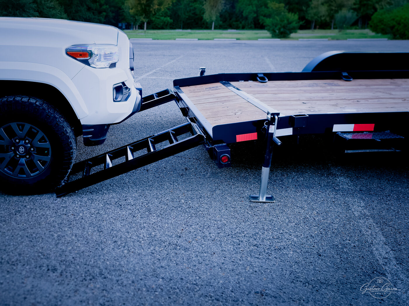 A steel loading ramp set down from the deck, stabilizer jack lowered
